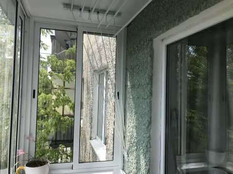 Раздвижные белые створки, на стене зелёная штукатурка, под потолком сушилка